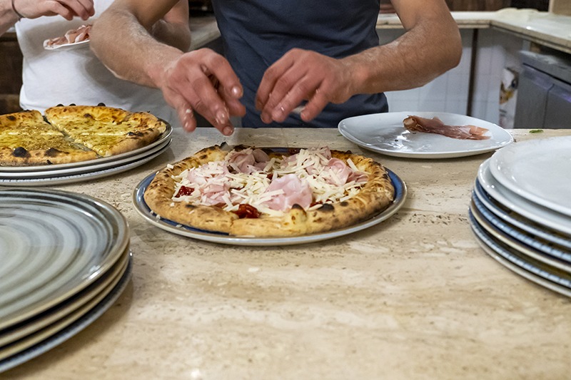 Preparazione delle pizze in cucina al San Cristobal